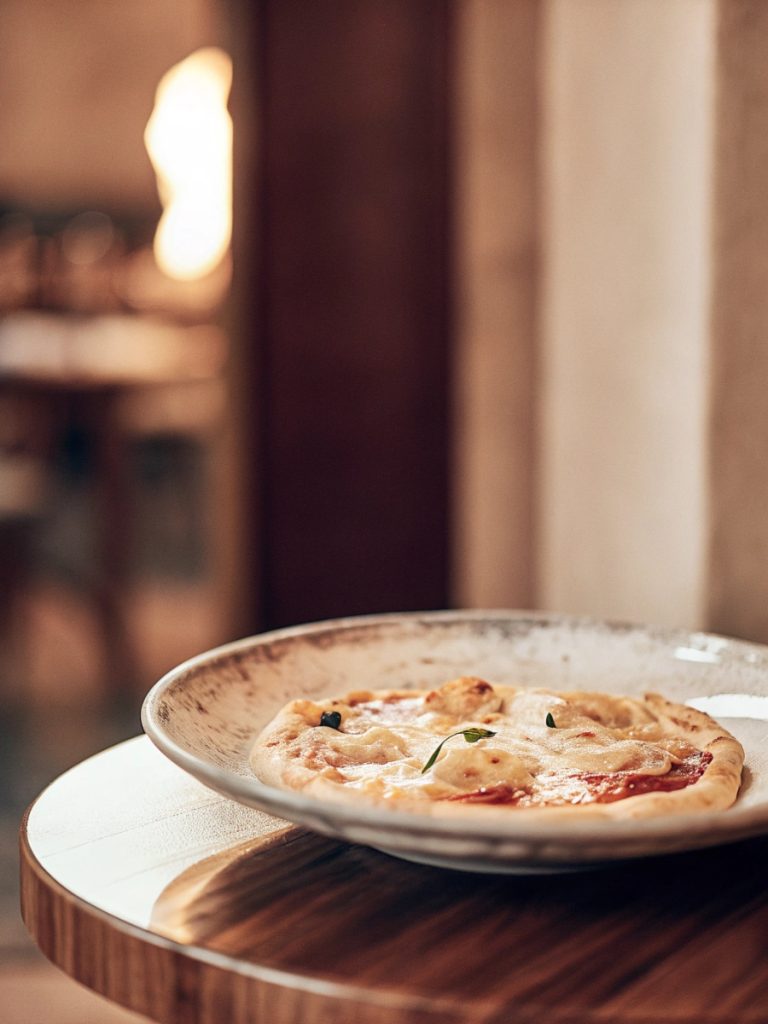 Prato de cozinha italiana com apresentação elegante inspirado em pizza e massas artesanais